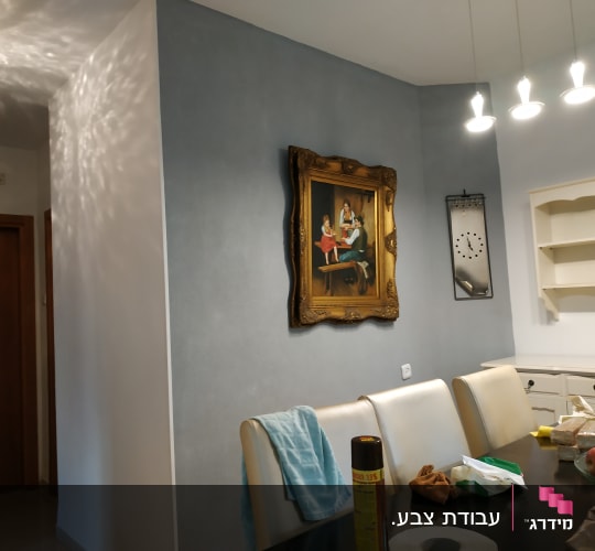 A framed painting on a wall in a dining room.